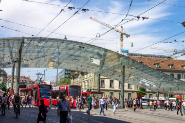 İsviçre, Bern 'de modern cam çatılı tren istasyonunda bir sürü insanın yürüdüğü bir cadde.