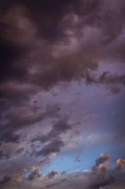 Koyu mor, gri bulutlu gökyüzünün dramatik bir görüntüsü.