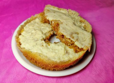 Ghevar - geleneksel Hint Diski şeklinde tatlı bir festival, renkli arka planda beyaz bir tabağa yerleştirilmiş.