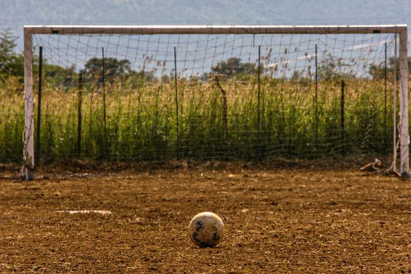 A ball in front of the soccer goal in a field