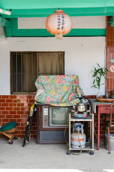 Tayvan 'da balkonda depolanmış eski eşyalarla dolu bir evin dikey görüntüsü.