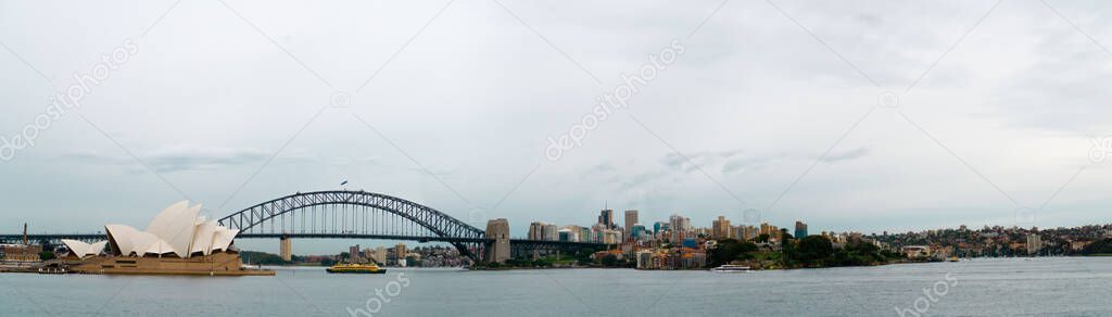 A Panoramic view a harbor bridge and the beautiful Sydney Opera House in Australia