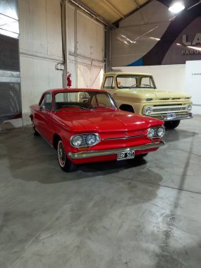 Avellaneda, Arjantin - 7 Mayıs 2022: Eski kırmızı Chevrolet Chevy Corvair Monza Coupe 1963 bir depoda. Expo Fierro 2022 klasik araba şovu. Kopyalama alanı.