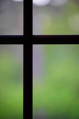 Üzerinde haç olan bulanık bir pencerenin dikey yakın çekimi.