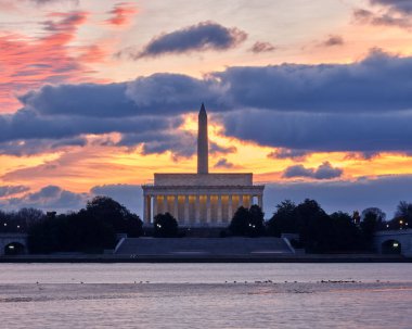 Washington DC 'nin ünlü manzarası (Washington Anıtı ve Lincoln Anıtı) gökyüzünün renkli olduğu sabah altın saatleriyle