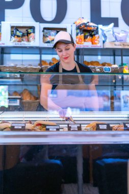 Girişimci kadın yeni yapılmış pastaları servis ediyor.