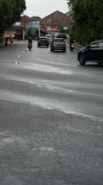 Araba ve motosikletli bir yolun dikey görüntüsü.