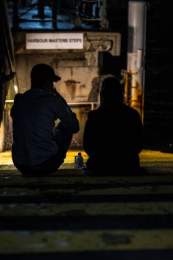 Gece hayatı, setin karşısındaki geçitte oturan bir çift..