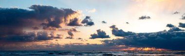 Gökyüzünde farklı tonlarda güzel bir günbatımının panoramik bir görüntüsü.