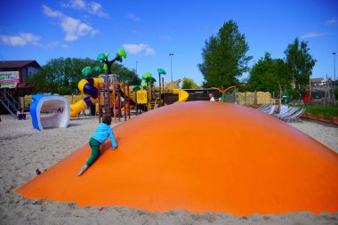 Park Wieloryba, Rewal, Polonya 'da çocuk parkında bir yastığın üzerinde zıplayan bir çocuk.