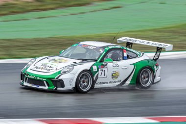 Islak yolda yarış arabası, yağmurlu bir günde. Porsche 911 Kupası 2017