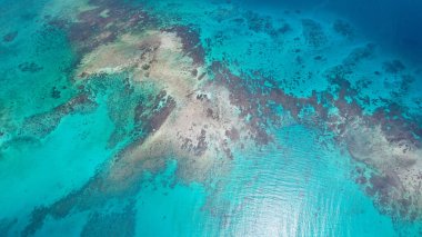 Filipinler 'de turkuaz okyanus suyu ve mercan resifleri olan güzel bir tropikal plajın hava manzarası.