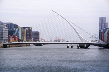 Santiago Calatrava 'nın Dublin' deki Liffey nehri üzerindeki sembolik Samuel Beckett köprüsü ile şehir manzarası. Modern, zarif, kablolu, harp şeklinde bir köprü..