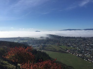 Kırsal bir bölgenin tepesinden güzel bir manzara. Arka plandaki her yeri sis kaplıyor.