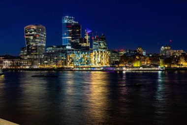 Geceleri Thames Nehri 'nin kıyısındaki binaların güzel manzarası