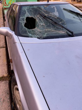 Dışarıdaki eski bir arabanın ön camı kırılmış.