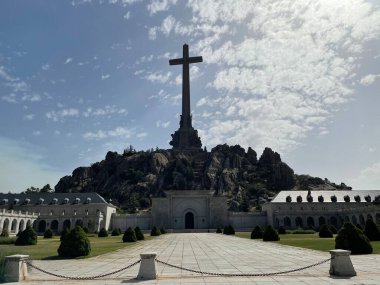 Arka planda bulutlu bir gökyüzü olan tepeye haç için büyük bir anıt dikildi.