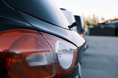 Park halindeki bir arabanın kırmızı arka farlarının yakın çekimi.