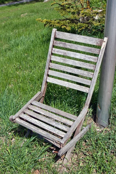 Een Verticaal Shot Van Een Gebroken Grijze Houten Stoel Tuin — Stockfoto