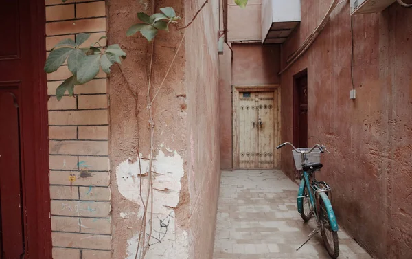 An old narrow passage into a building with a parked bicycle