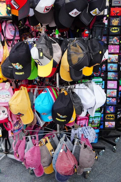 Tiro Vertical Diferentes Bonés Coloridos Pendurados Uma Rocha Para Venda — Fotografia de Stock