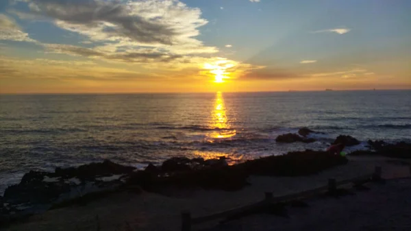 Sakin Bir Denize Karşı Kumlu Bir Sahilin Manzarası Günbatımını Yansıtıyor — Stok fotoğraf