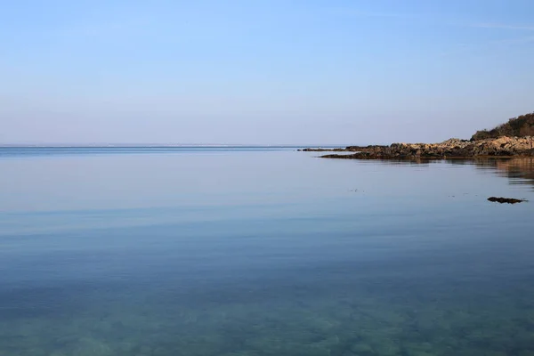 Ein Malerischer Blick Auf Ein Ruhiges Meer Mit Felsigem Ufer — Stockfoto