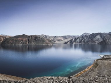 Dağların yakınındaki güzel bir gölün alçak açılı görüntüsü.