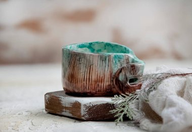 Ahşap bir yüzey üzerinde eski bir seramik kupanın yakın plan fotoğrafı.