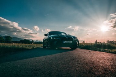 Günbatımında modern bir BMW M4 'ün, Dağ v. lüks spor arabalı görüntüsü birçok sürücünün hayalindeki arabadır.