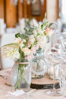 Düzenlenmiş bir yemek masasında çiçeklerle süslenmiş dikey bir poz.