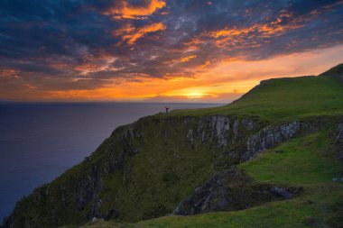 Gün batımında dağların yakınında güzel bir deniz manzarası.
