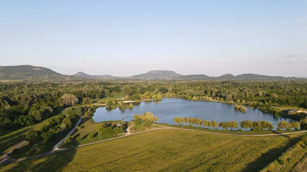 広大な緑の農地の中に小さな静かな池の空中ドローンショット — ストック写真