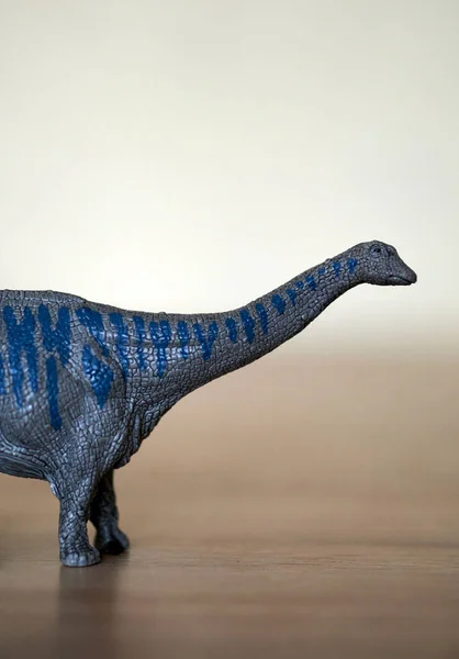 Eine Nahaufnahme Einer Grau Blauen Dinosaurier Spielzeugfigur Auf Einer Holzoberfläche — Stockfoto