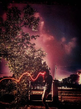 Gece parkta bir kişinin dikey uzun pozlama görüntüsü.