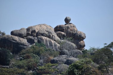 Mavi gökyüzüne karşı gri kayalar.