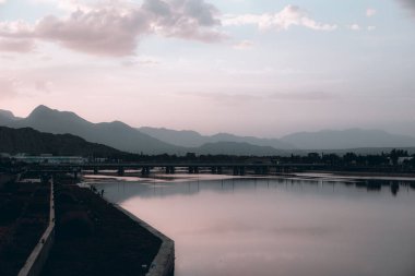 Arkasında dağlar olan nehir kenarının güzel bir manzarası.