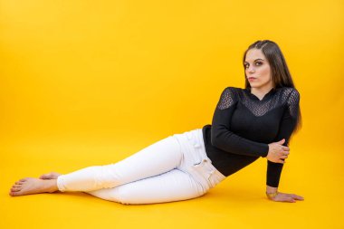 Stüdyoda fotoğraf çektirmek için poz veren beyaz bir kadın.