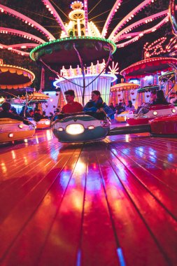 Bir eğlence parkında ışık efektli gençlerin dikey düşük açılı çekimi.