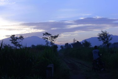 Bulutlu arka planda dağlarda güzel bir güneşin doğuşunun manzarası.