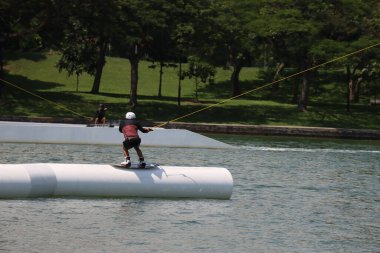 Güneşli bir günde iki genç sörf yapıyor.
