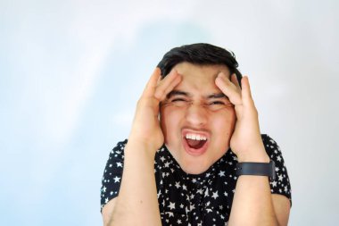 Elleri başının üstünde bağıran genç bir adam.