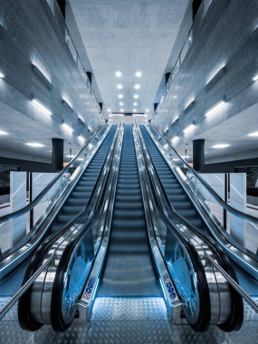 Modern yürüyen merdivenleri iş binasının içine taşırken çekilen dikey bir görüntü.