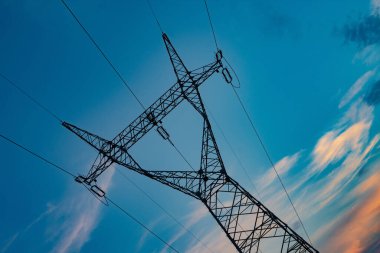 Gün batımında yüksek gerilim hatlarının alçak açılı çekimi.