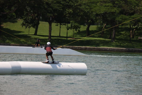 Güneşli bir günde iki genç sörf yapıyor.