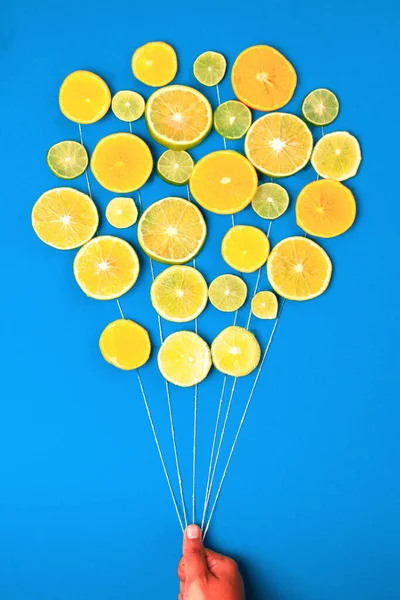 ライムとレモンの輪切りと風船として人間の指を持つ創造的な食品の概念 — ストック写真