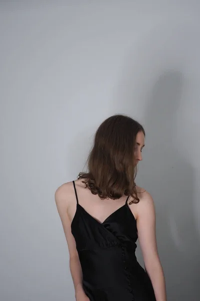 一个穿着时髦衣服 靠着灰色墙壁摆姿势的女孩的特写镜头 — 图库照片