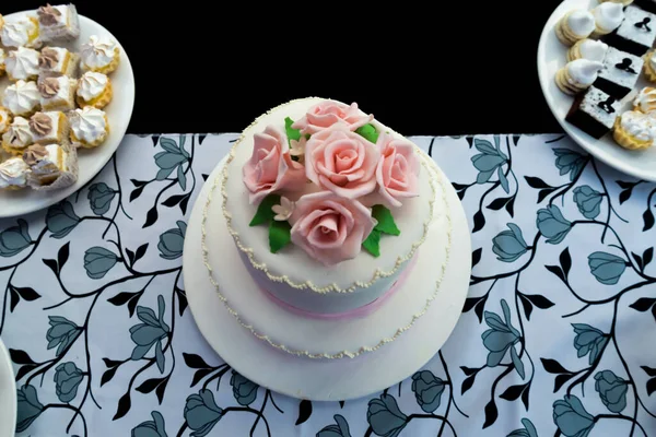 Ein Zweistöckiger Floraler Kuchen Und Verschiedene Süßigkeiten Auf Einem Tisch — Stockfoto