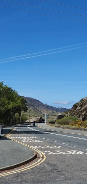 Tiro Vertical Motociclista Sua Moto Dirigindo Longo Estrada Asfalto Contra — Fotografia de Stock