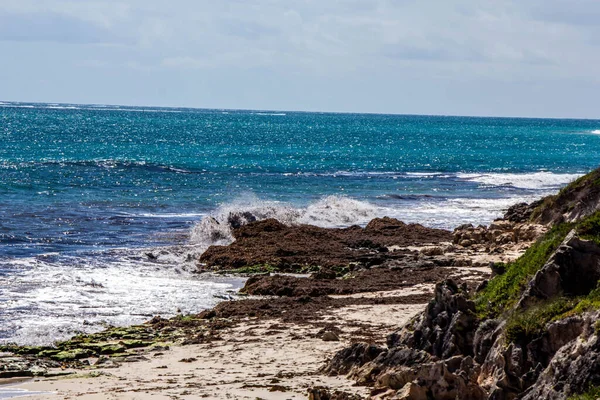 Красивый Снимок Пляжа Водой Ударяющейся Делающей Брызги Облачным Небом — стоковое фото